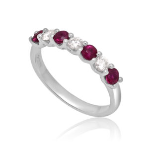 A platinum ruby and diamond seven stone half eternity ring with a v-collet setting, belonging to H. L. Brown's Volante collection.