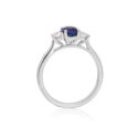 A platinum oval sapphire and round brilliant cut diamond three stone ring.