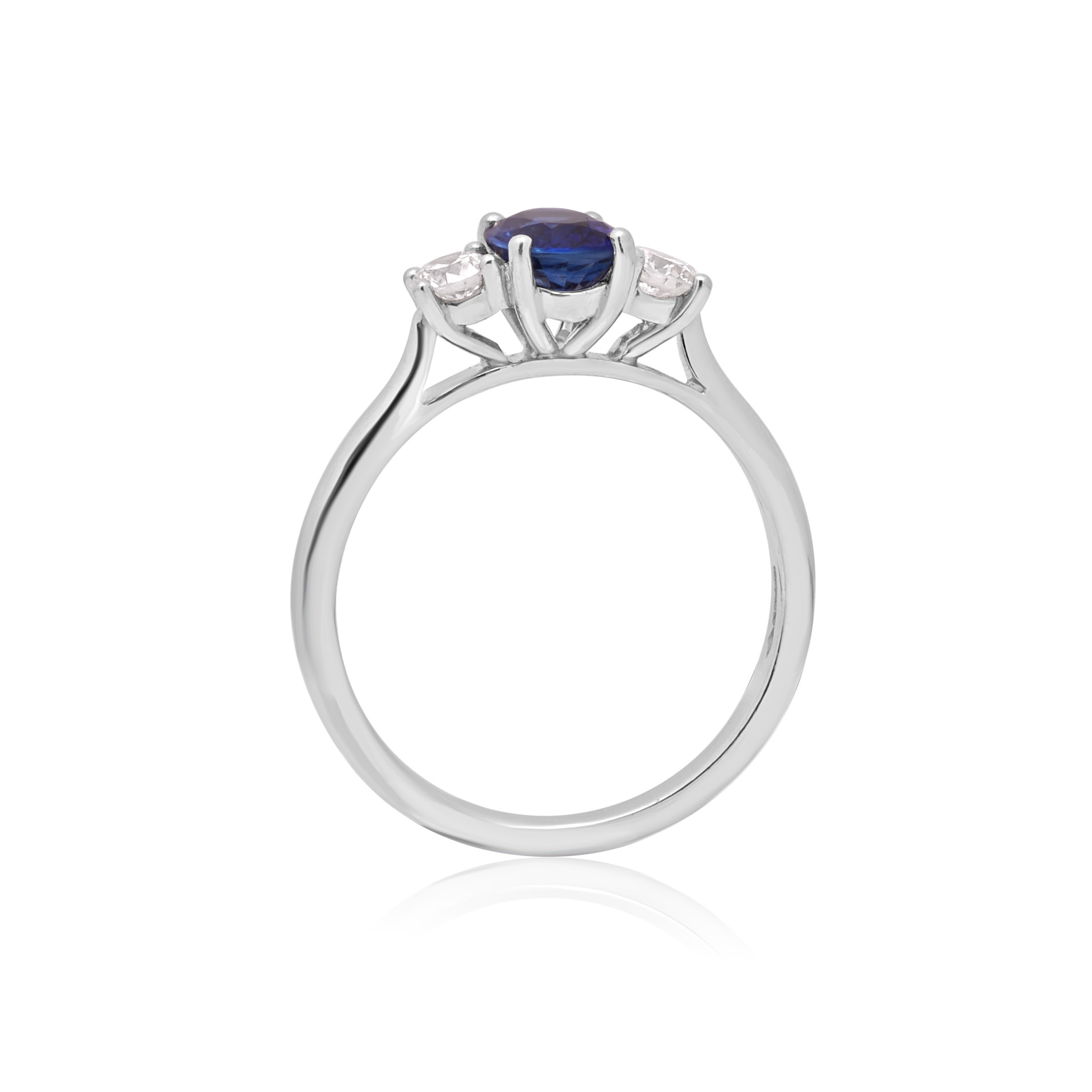A platinum oval sapphire and round brilliant cut diamond three stone ring.