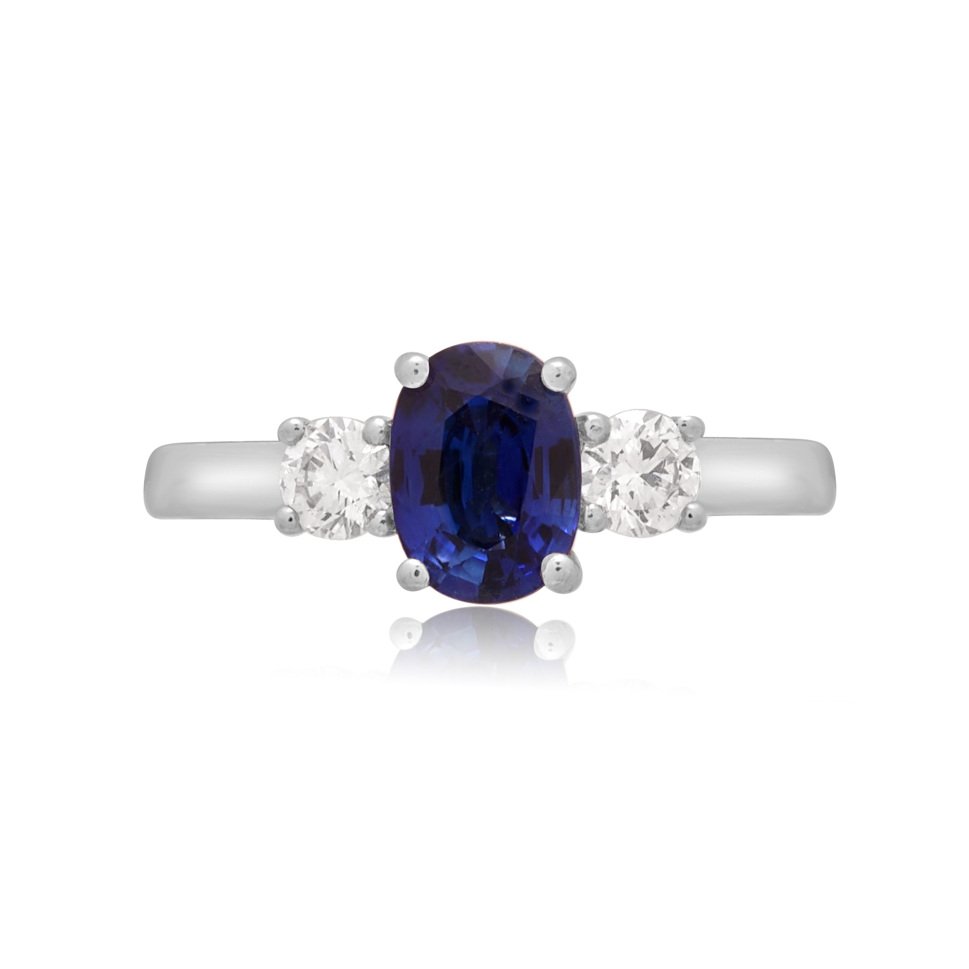 A platinum oval sapphire and round brilliant cut diamond three stone ring.