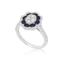 18ct White Gold Sapphire & Diamond Flower Cluster Ring An 18ct white gold oval shaped sapphire and diamond flower cluster ring, with diamond set shoulders.