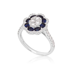 An 18ct white gold oval shaped sapphire and diamond flower cluster ring, with diamond set shoulders.