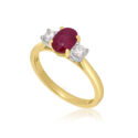 An 18ct yellow gold oval ruby and round brilliant cut diamond three stone ring.