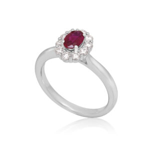 A platinum, oval shaped ruby and brilliant cut diamond set cluster ring.