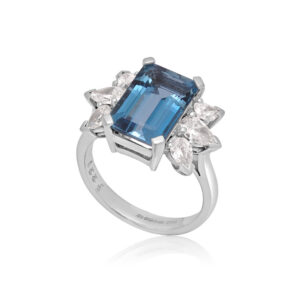 An 18ct white gold emerald cut aquamarine ring with pear shaped diamond set shoulders.