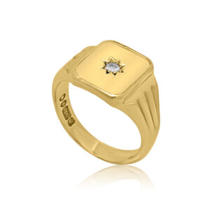 A 9ct yellow gold oblong shaped signet ring set with a single diamond.