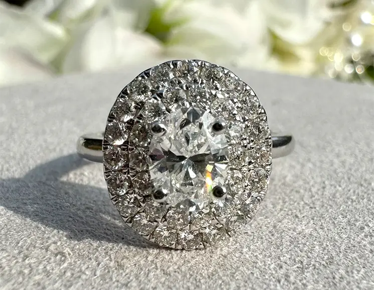 A diamond set cluster ring with a floral background.