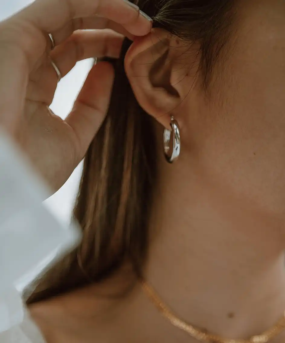 A close up of a woman's face focussing on the earring in her ear.