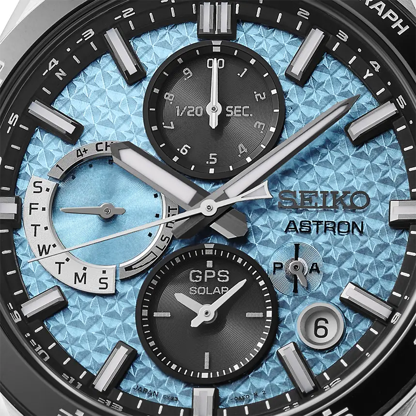 A close up of a blue and black Seiko Astron watch face.