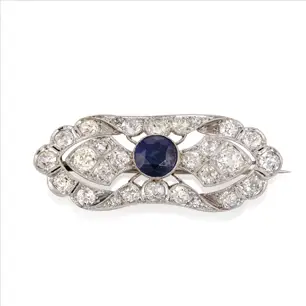 A sapphire and diamond set period style brooch in white gold, on a white background.